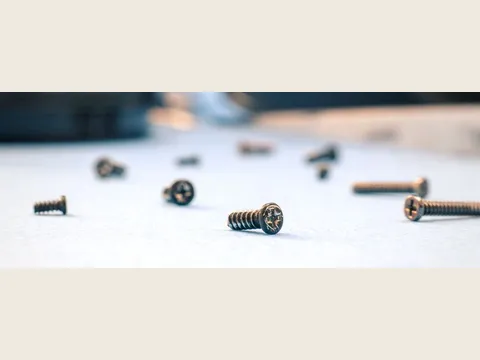 Tornillos metálicos sobre una superficie de trabajo clara