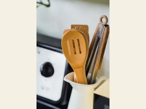 Utensilios de madera y metal en un recipiente